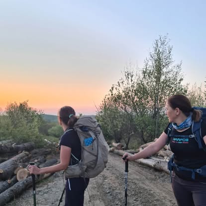 Dvoje planinara na grebenu u svjetlu zalaska sunca